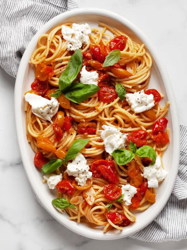 Burrata pasta with roasted tomatoes on an oval serving platter.