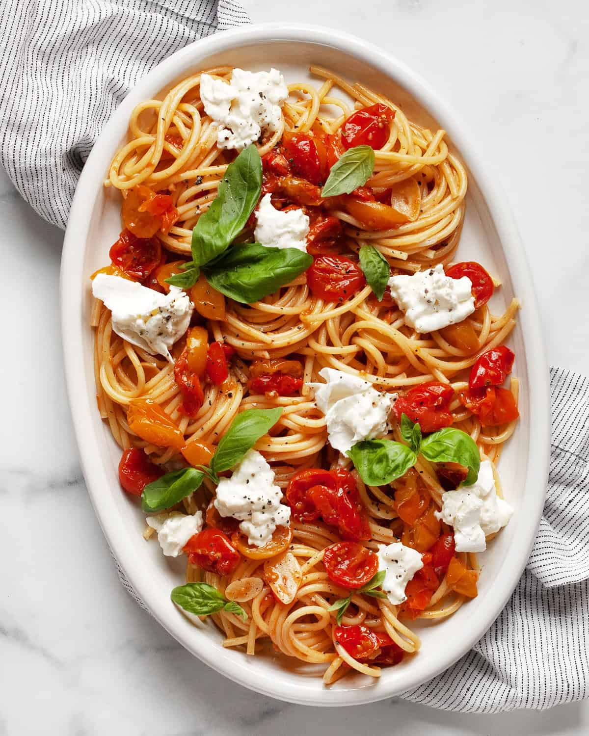 Burrata pasta with roasted tomatoes on an oval serving platter.