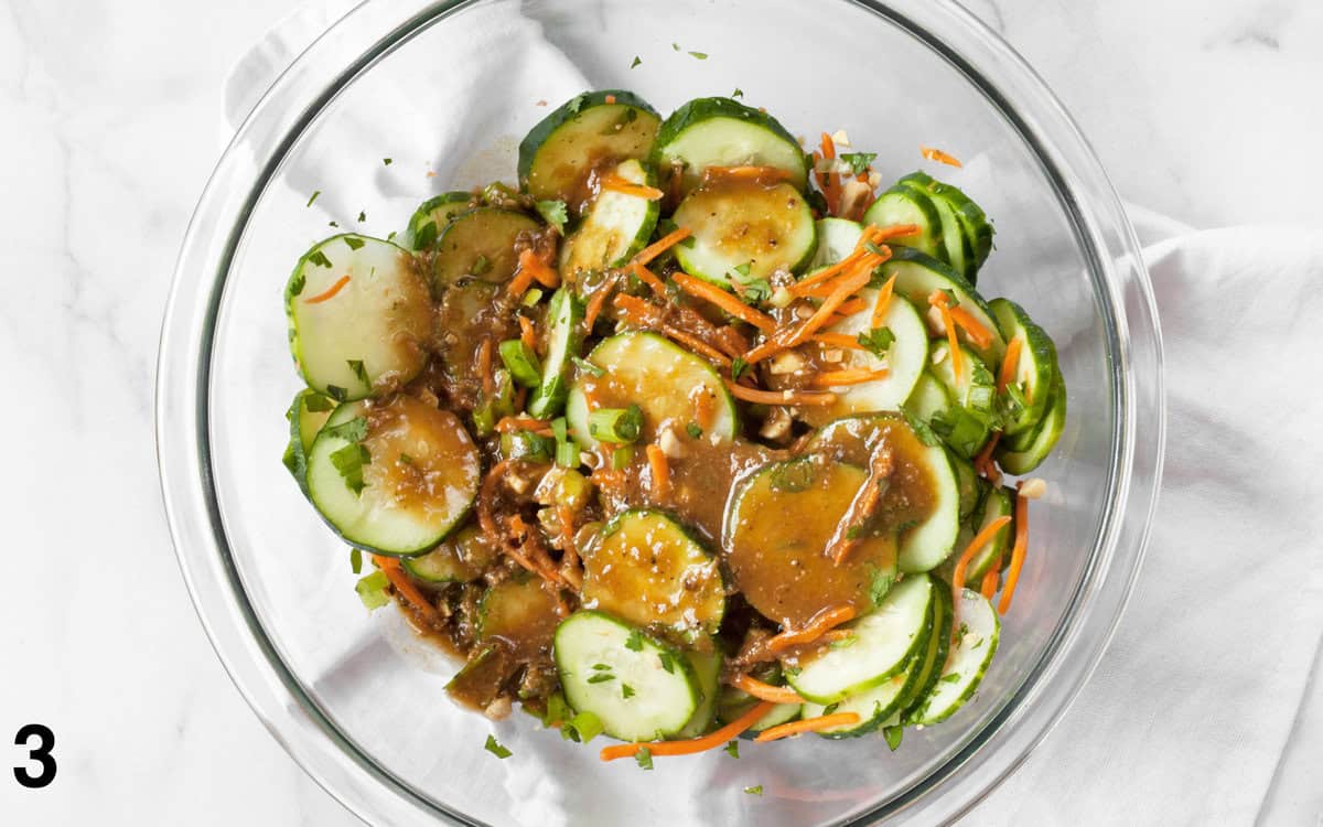 Salad and dressing tossed in a bowl.