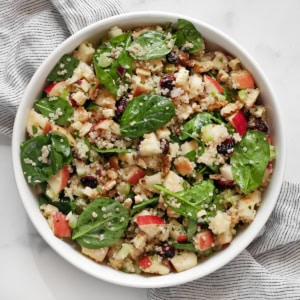 Apple salad with quinoa and baby spinach in a bowl.