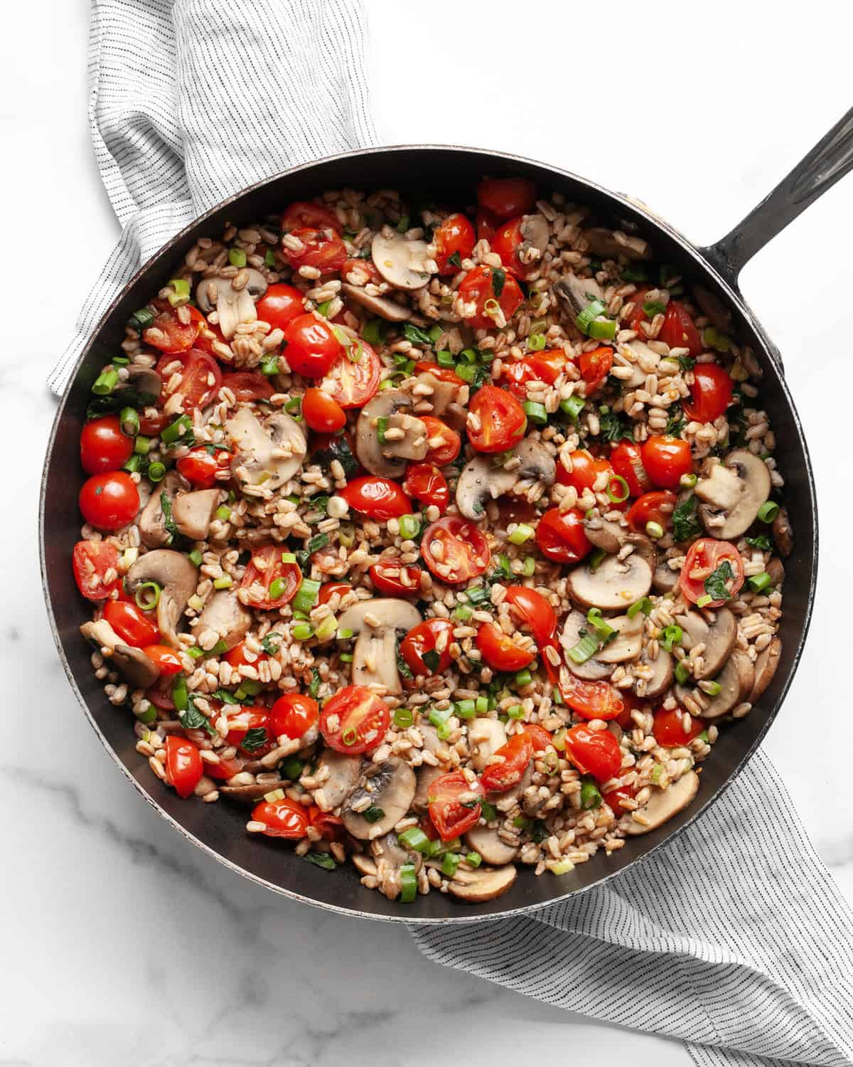 Mushroom tomato farro in a skillet.