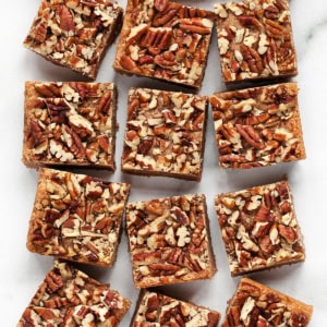 Pecan cinnamon bars cut into squares lined up in rows.