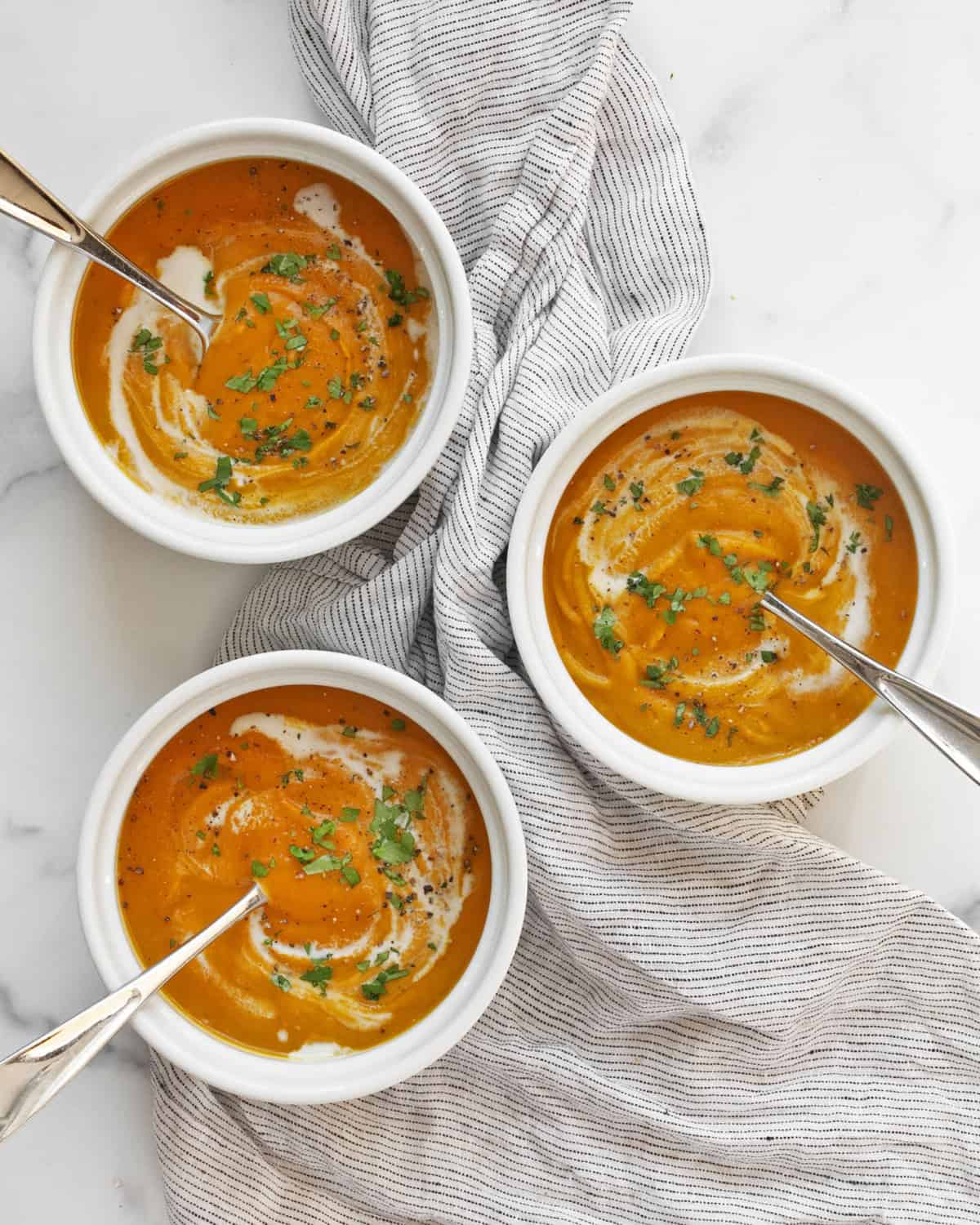 Three bowls of roasted kabocha squash soup.