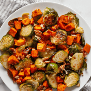 Roasted sweet potatoes and brussels spouts on a plate.