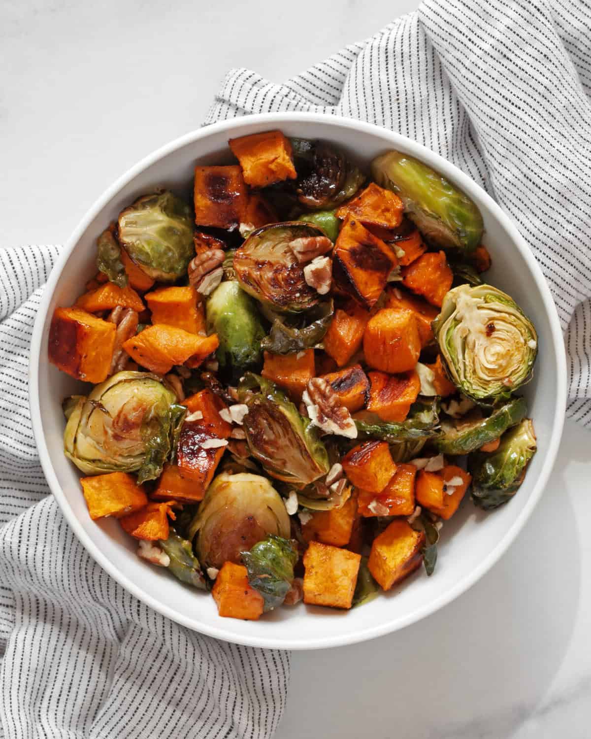 Roasted sweet potatoes and brussels spouts in a bowl.