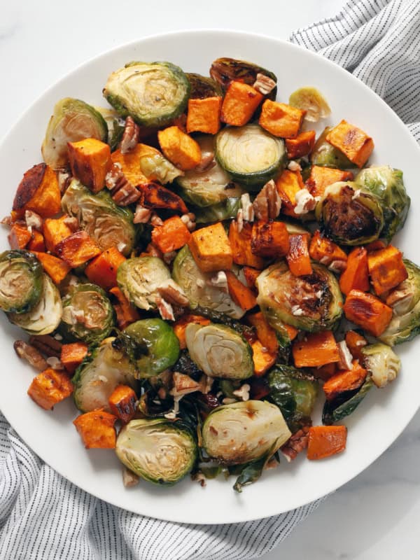 Roasted sweet potatoes and brussels spouts on a plate.