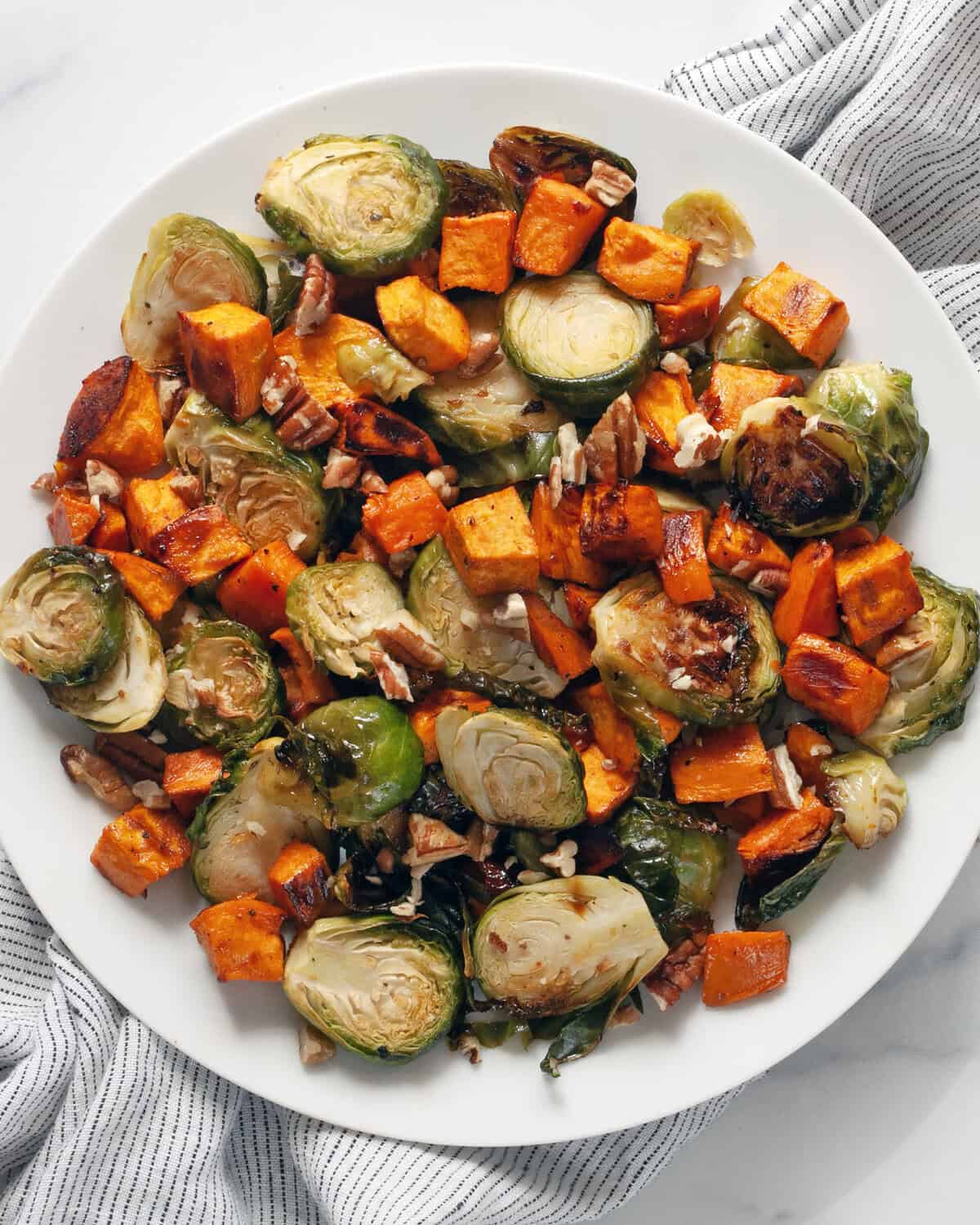 Roasted sweet potatoes and brussels spouts on a plate.