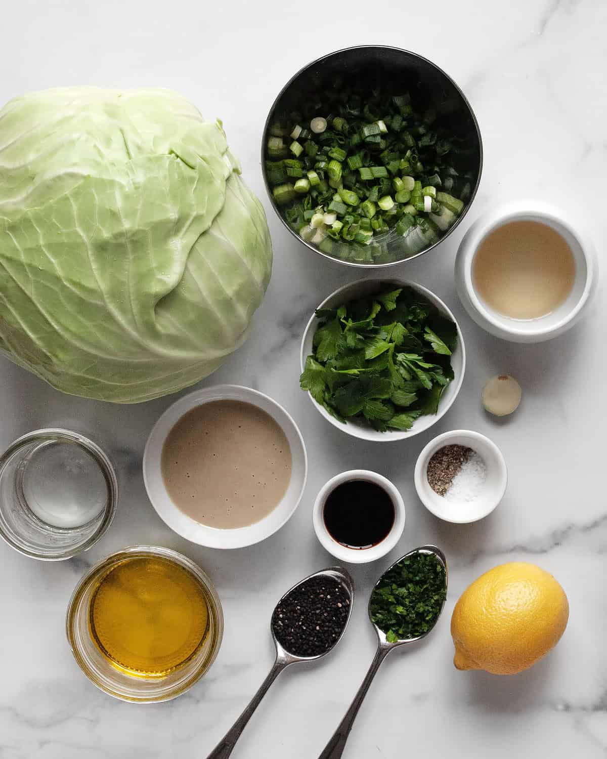 Ingredients green cabbage, scallions, parsley, tahini, lemon, olive oil, rice vinegar, garlic, salt, pepper and water.