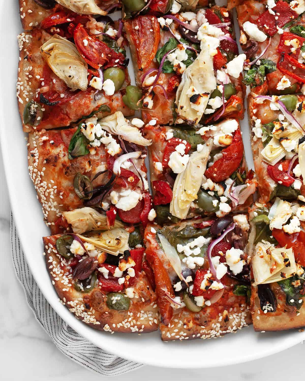 Pizza cut into squares on a serving plate.