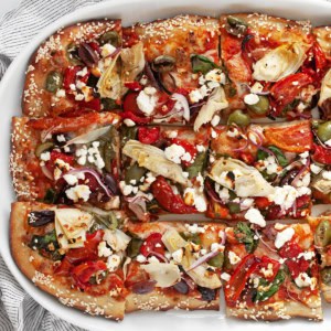 Pizza cut into squares on a serving plate.