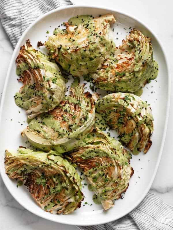 Roasted cabbage wedges on an oval platter.