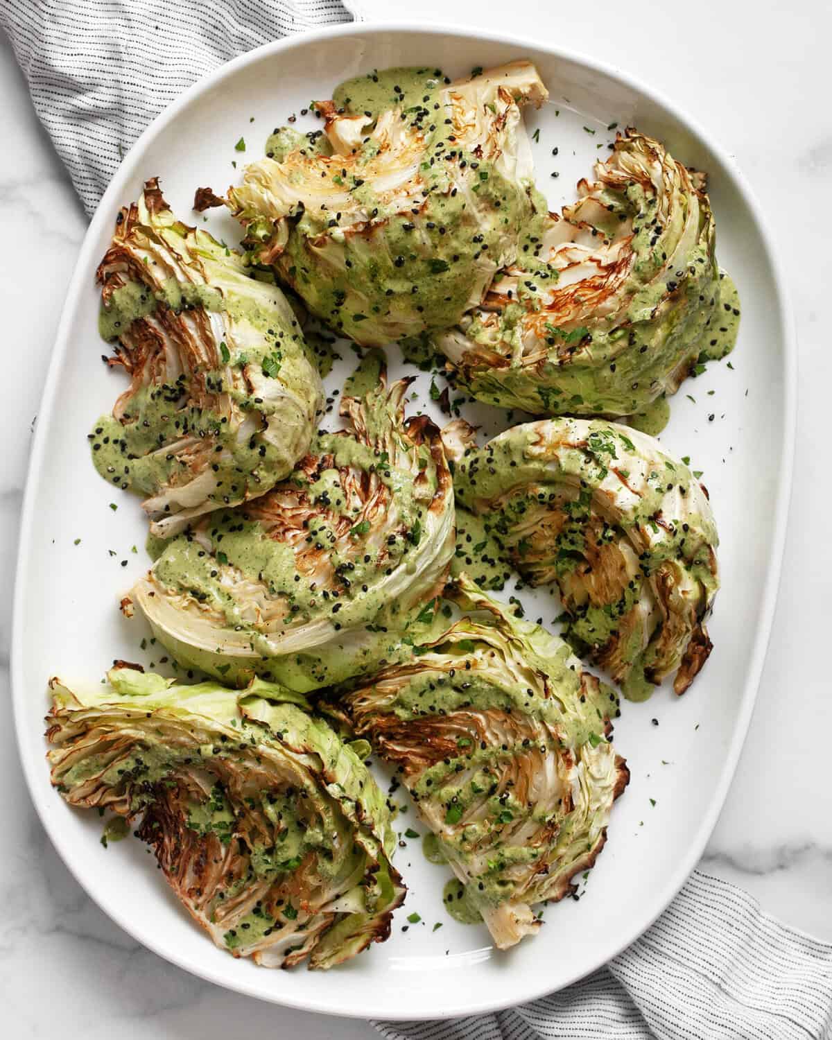 Roasted cabbage wedges on an oval platter.