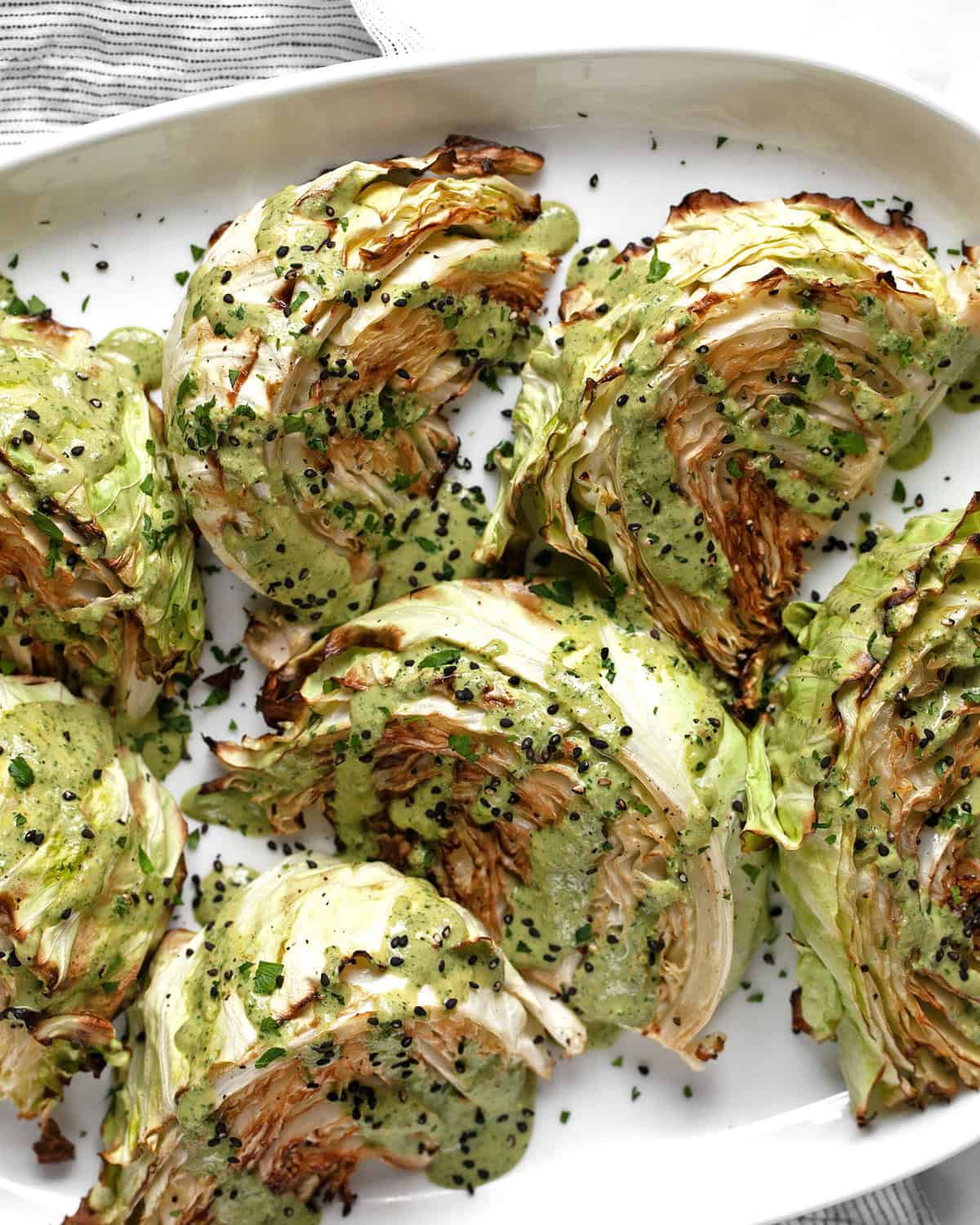 Roasted cabbage wedges on an oval platter.