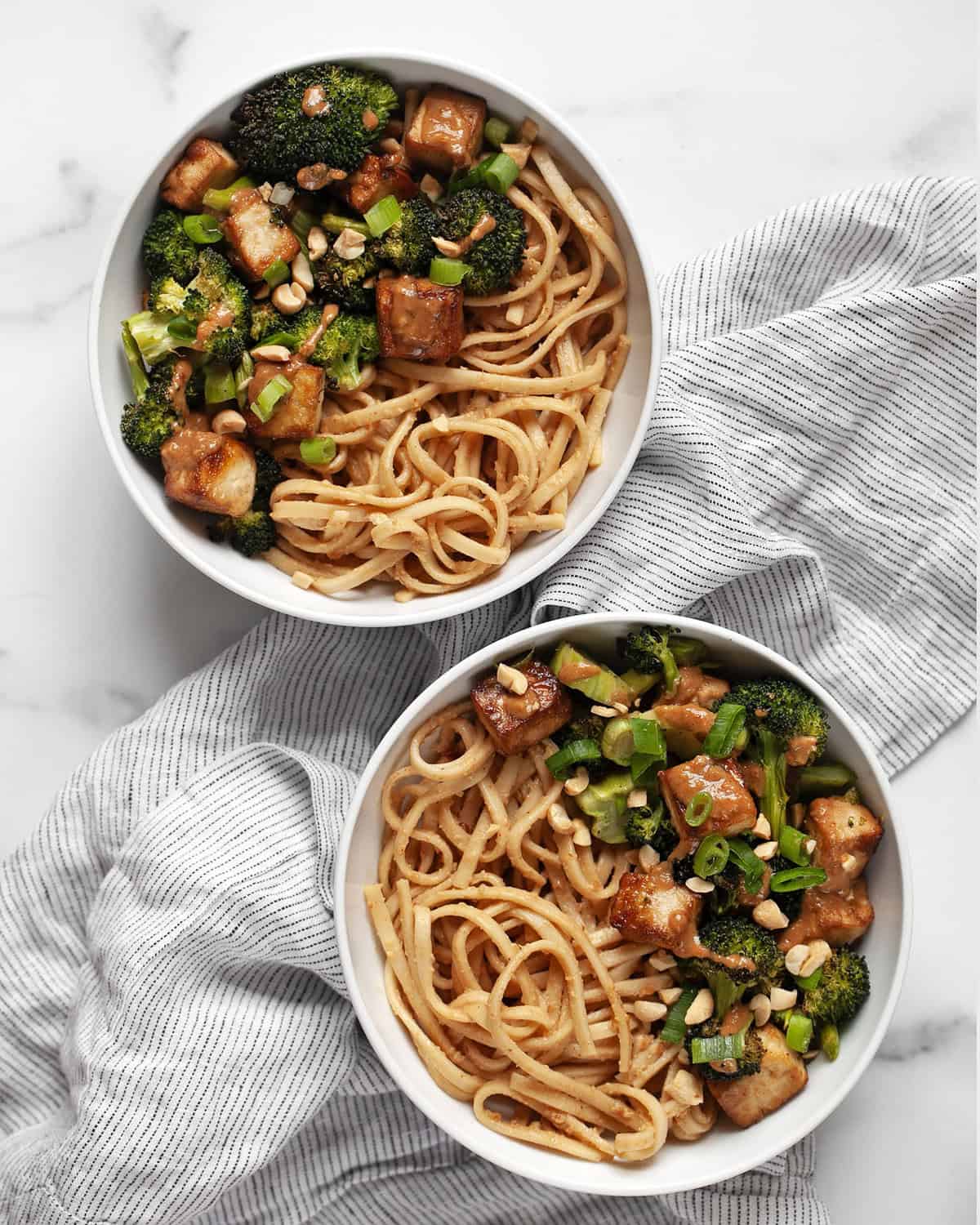 Two roasted broccoli tofu bowl with peanut noodles.