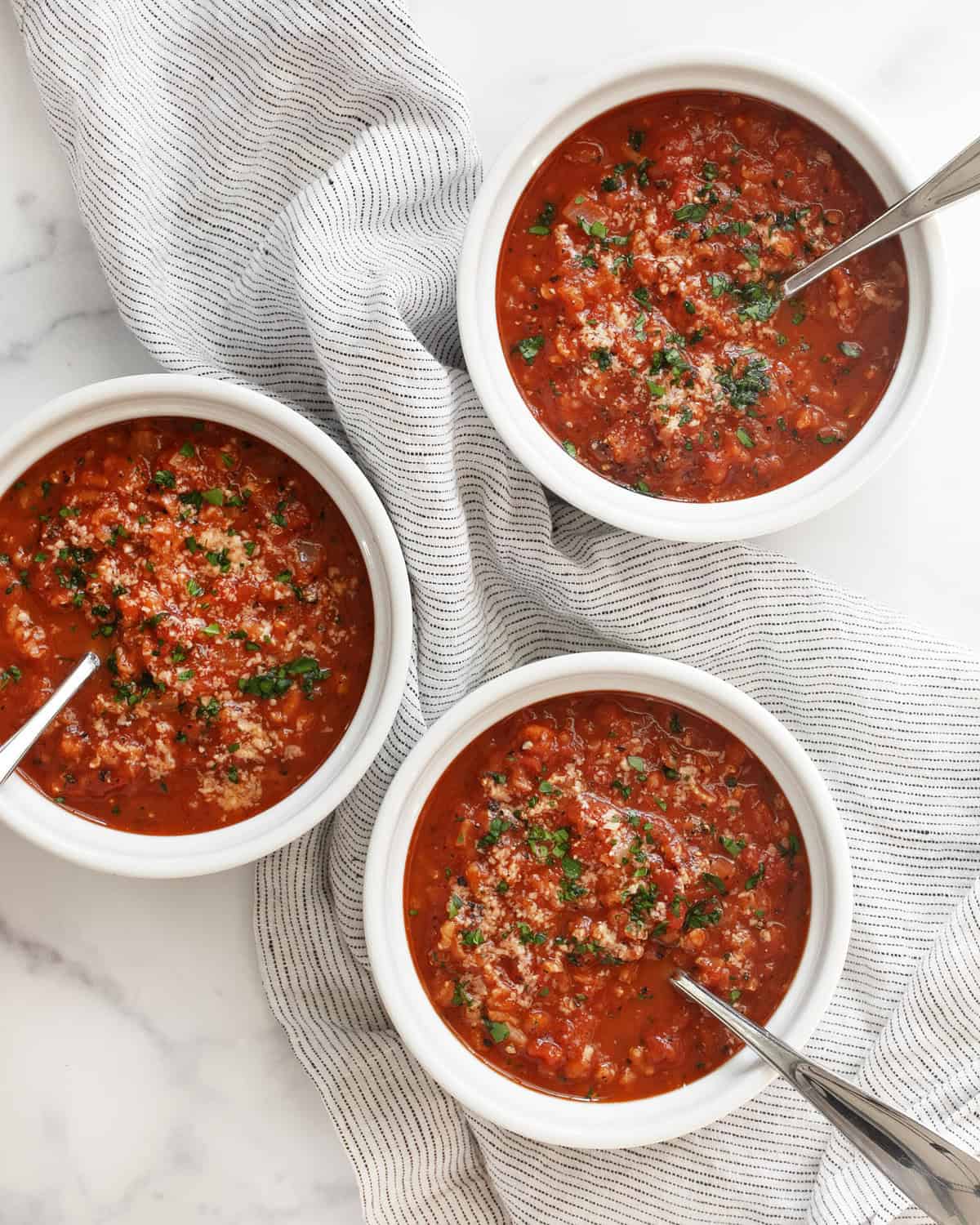 Three bowls of tomato rice soup.