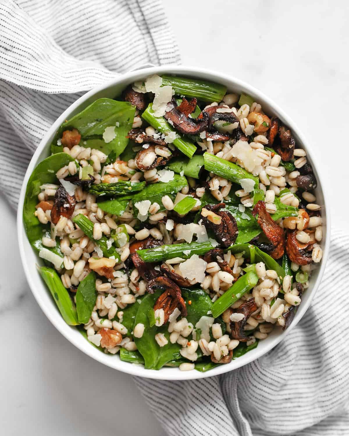 Barley salad with roasted asparagus and mushrooms in a bowl.