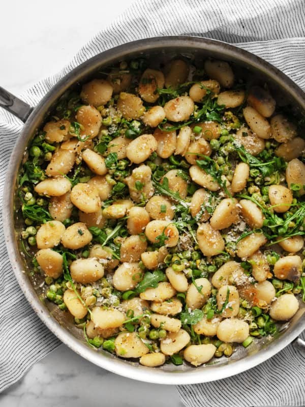 Gnocchi with smashed peas in a skillet.