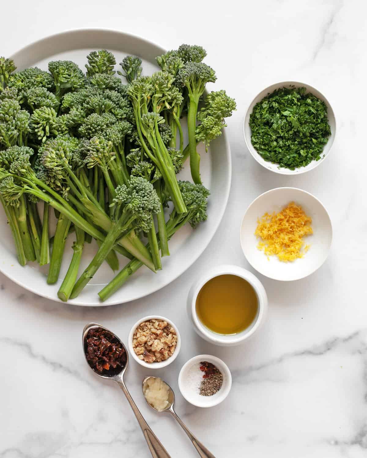 Ingredients including broccolini, parsley, lemon zest, garlic, walnuts, sun dried tomatoes, salt and pepper.